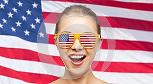 Happy teenage girl in shades with american flag