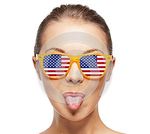 Happy teenage girl in shades with american flag