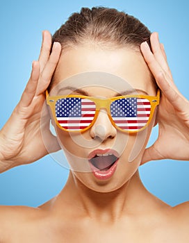 Happy teenage girl in shades with american flag