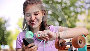 Happy teenage girl with smartphone and longboard