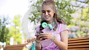 Happy teenage girl with smartphone and longboard