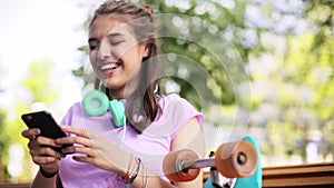 Happy teenage girl with smartphone and longboard