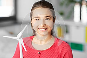 Happy teenage girl with toy wind turbine