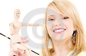 Happy teenage girl with wooden model dummy