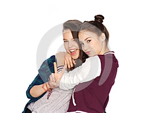 Happy teenage girls hugging and showing peace sign