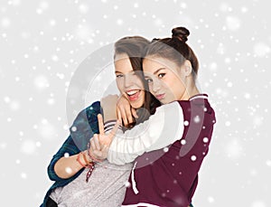 Happy teenage girls hugging and showing peace sign