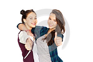 Happy teenage girls hugging and showing thumbs up