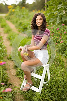 Happy teenage high school senior girl in sunflower field