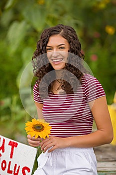 Happy teenage high school senior girl in sunflower field