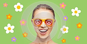 Happy teenage hippy girl in shades with peace sign