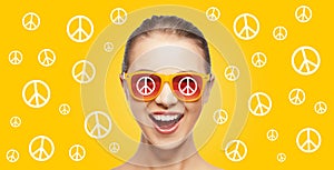 Happy teenage hippy girl in shades with peace sign