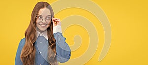 Happy teenage school girl fix eyeglasses smiling yellow background, eyewear. Child face, horizontal poster, teenager