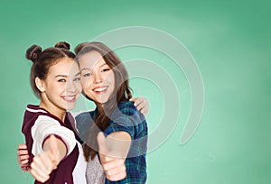 Happy teenage student girls showing thumbs up