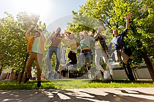 Happy teenage students or friends jumping outdoors