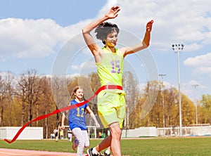 Happy teenage winner crossing the finish line