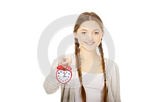 Happy teenage woman with alarmclock.