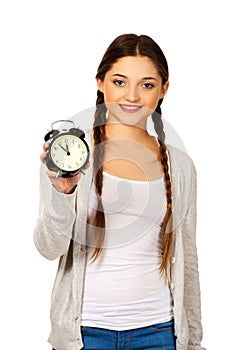 Happy teenage woman with alarmclock.