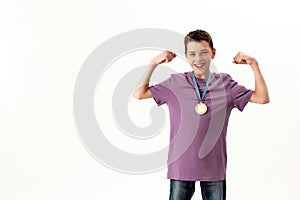 Happy teenaged disabled boy with cerebral palsy wearing gold medal, smiling at camera, raising clenched fists, feeling