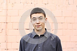 Happy teenager boy grimace wink closeup portrait on white wall background