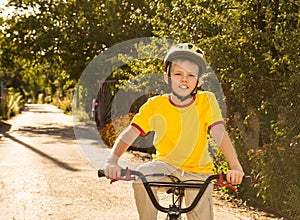 Happy teenager boy safely riding the bicycle on the countryside