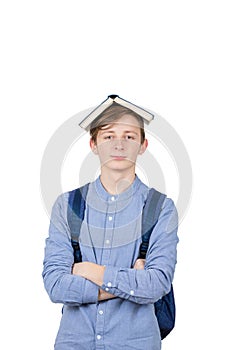 Happy teenager boy smiling and looking to camera holding book on his head. Book lover. Ready to study hard