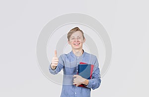 Happy teenager boy smiling  thumb up gesture holding books. Book lover. Ready to study hard