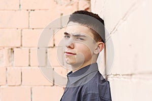 Happy teenager boy wink closeup portrait on white wall background