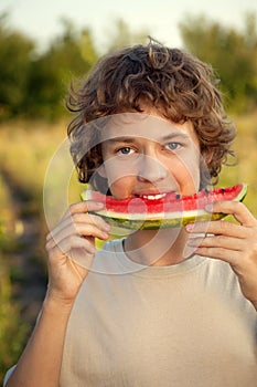 Happy teenager eating watermelon