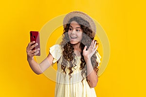 Happy teenager girl 12, 13, 14 years old with smart phone. Hipster teen girl types message on cellphone, enjoys mobile