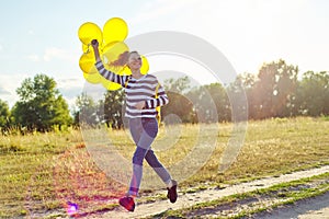 Happy teenager girl with balloons running and jumping along country road