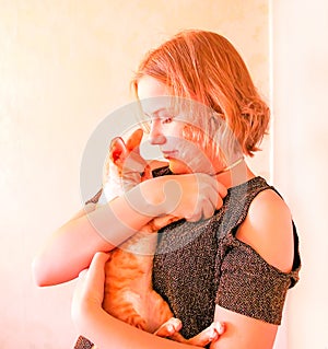 Happy teenager girl holding adorable little devon rex cat