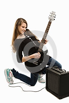 Happy teenager girl playing guitar