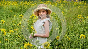 Happy teenager girl smiling on sunflowering meadow in sunny village. Portrait smiling girl posing on sunflower field in