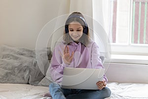 Happy teenager girl talk on video call on laptop