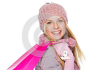 Happy teenager girl in winter hat and scarf with shopping bag
