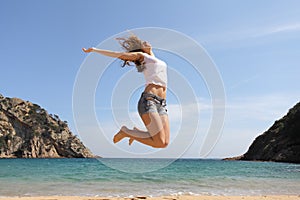 Happy teenager jumping on the beach