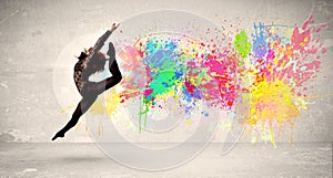 Happy teenager jumping with colorful ink splatter on urban background