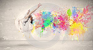 Happy teenager jumping with colorful ink splatter on urban background