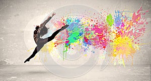 Happy teenager jumping with colorful ink splatter on urban background