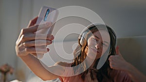 Happy teenager making selfie with headphones closeup. Joyful girl having fun