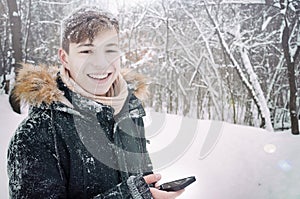Happy Teenager with phone in winter park