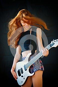 Happy teenager playing electric guitar