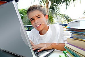 Happy teenager student boy working laptop