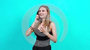 Happy teenager talking on the phone excitedly. Charming girl, dressed in black T-shirt with cleavage