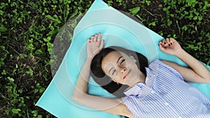 Happy teenager,top view of young smiling woman lying on the grass,happiness and outdoor recreation concept