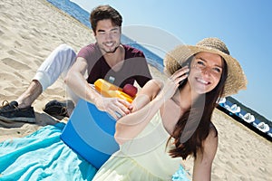 Happy teenagers calling their friends while enjoying beach