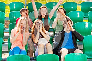 Happy teenagers cheer for the team during game