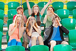Happy teenagers cheer for the team during game photo