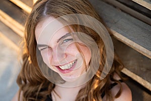 Happy teenagers face. Cheerful young woman with joyful and charming smile. Ginger girl relaxing indoors.