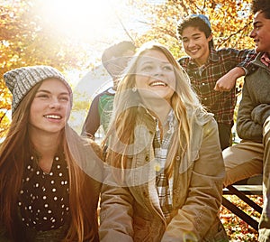 Happy, teenagers and friends outdoor in park for relaxing day on summer vacation of semester break, together and talking photo